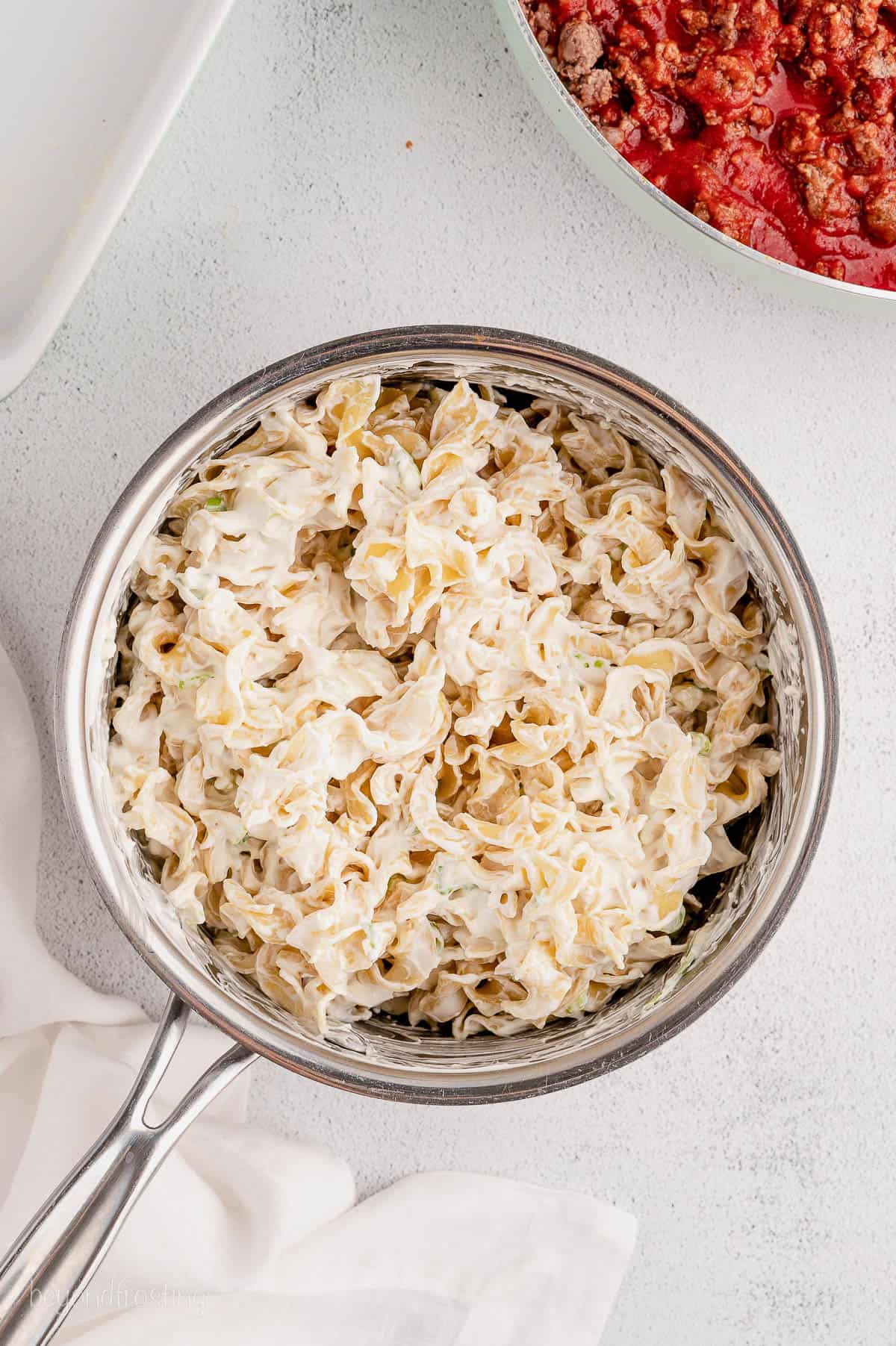 Egg noodles mixed with sour cream and cream cheese in a pan