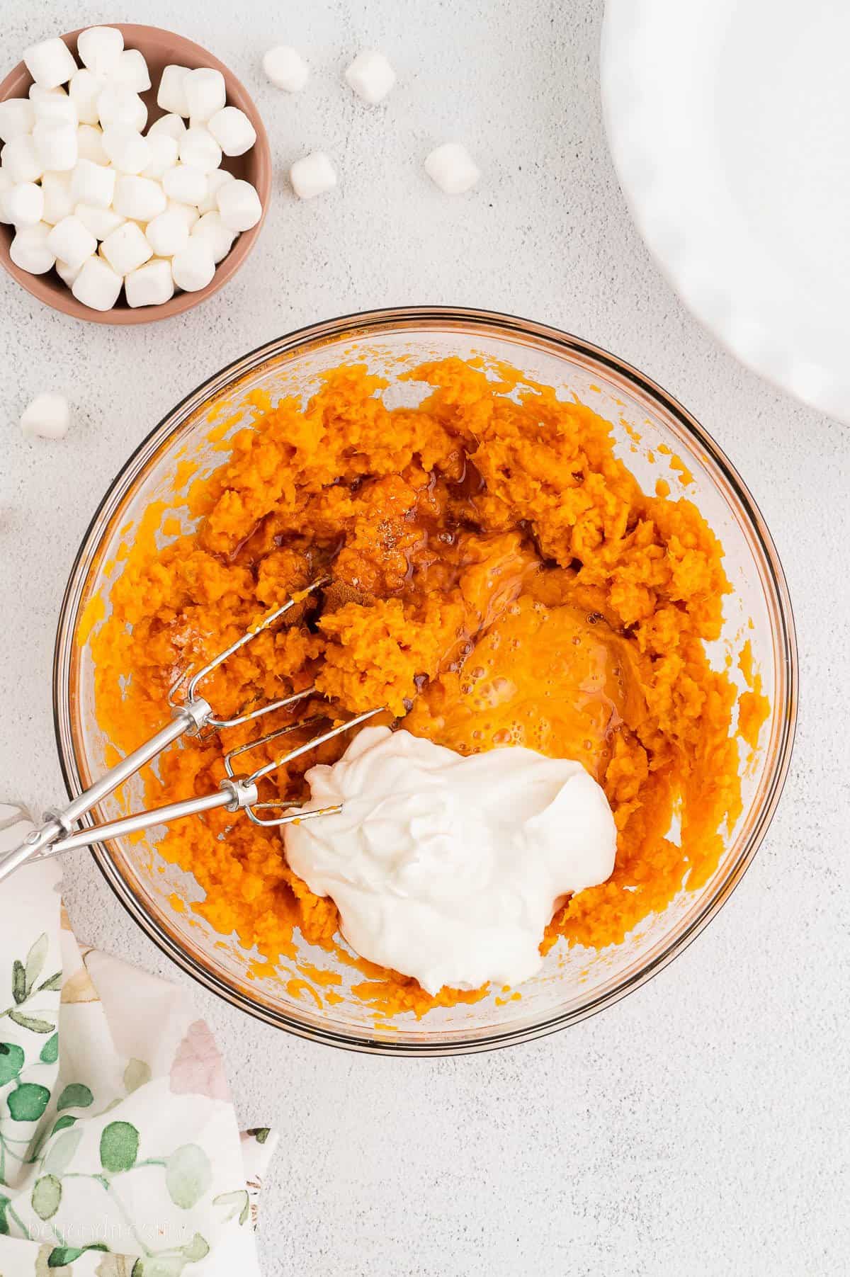 Eggs and yogurt are added to mashed sweet potatoes to created sweet potato casserole filling.
