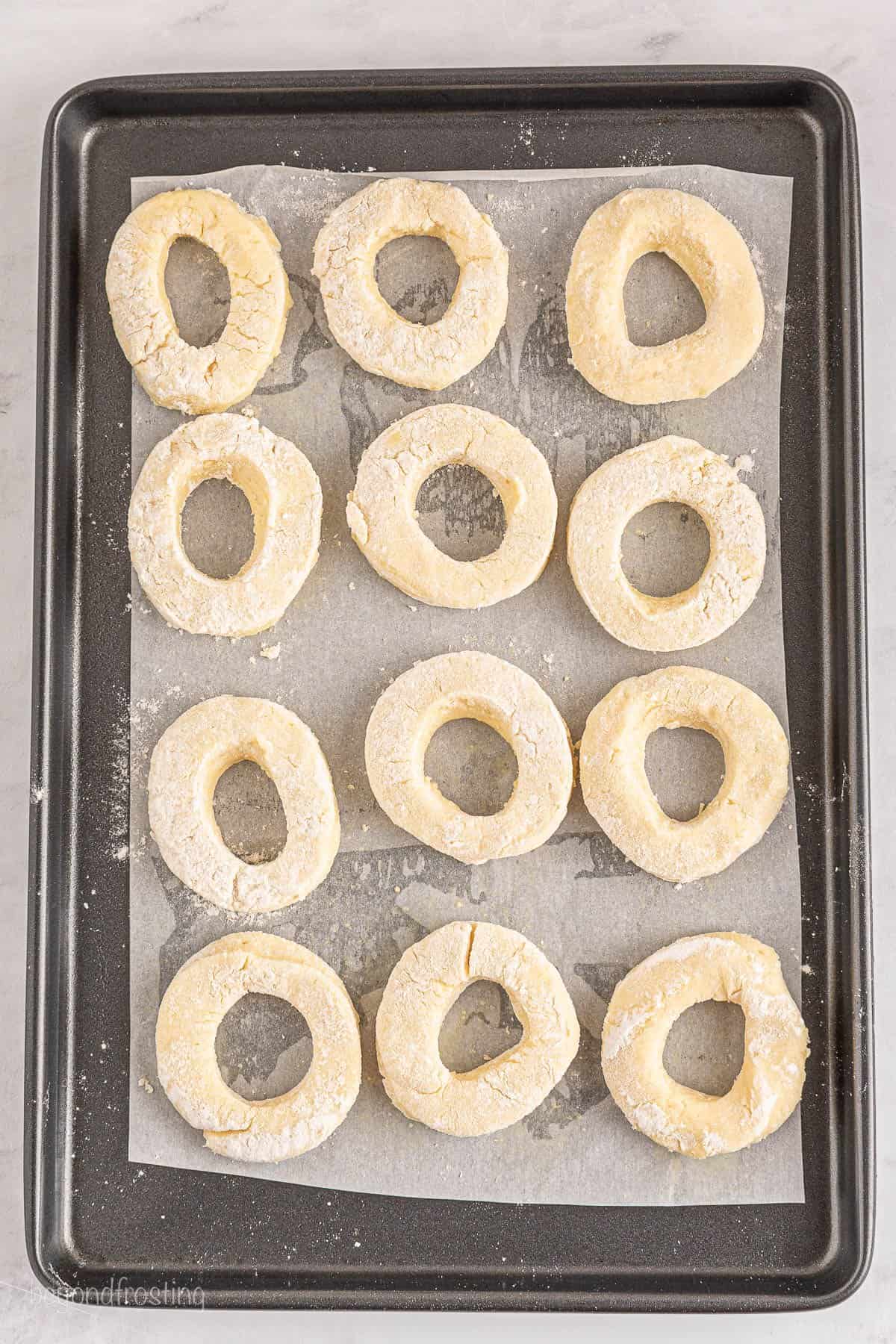 Uncooked donuts on a baking sheet