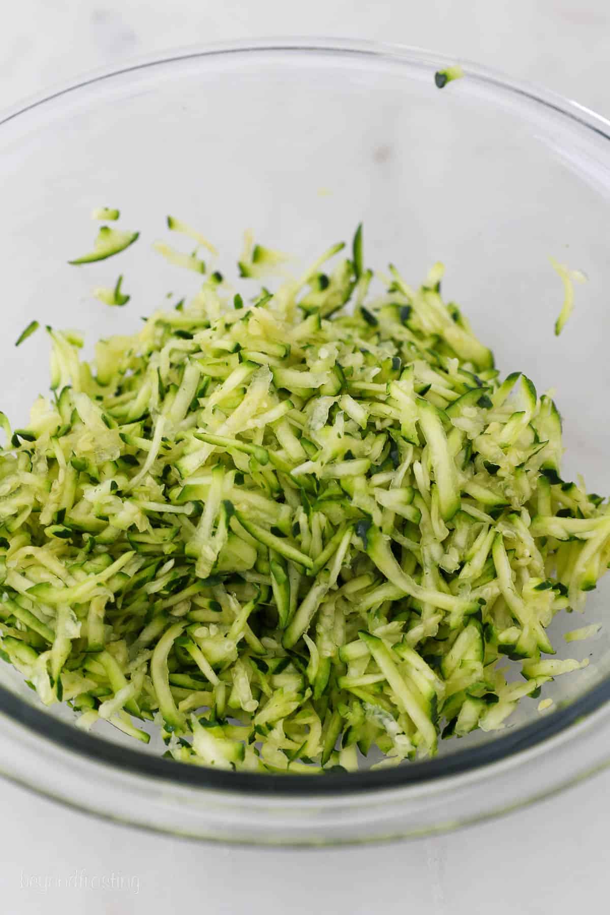 grated zucchini in a glass mixing bowl