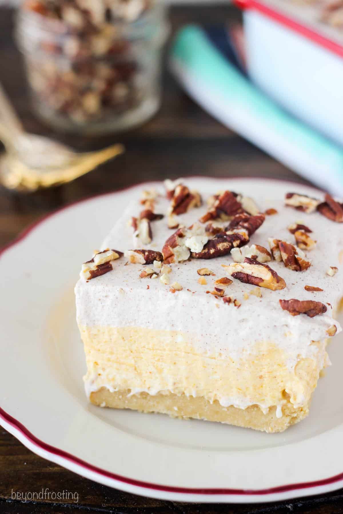 a square of pumpkin icebox cake on a plate topped with pecans