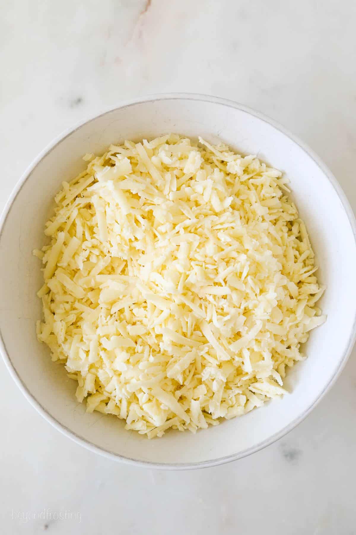 A bowl of shredded sharp white cheddar cheese