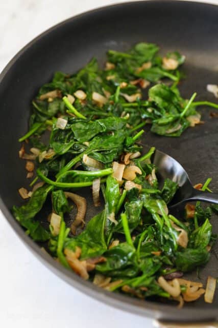 Sauteed spinach, garlic, and scallions in a pan