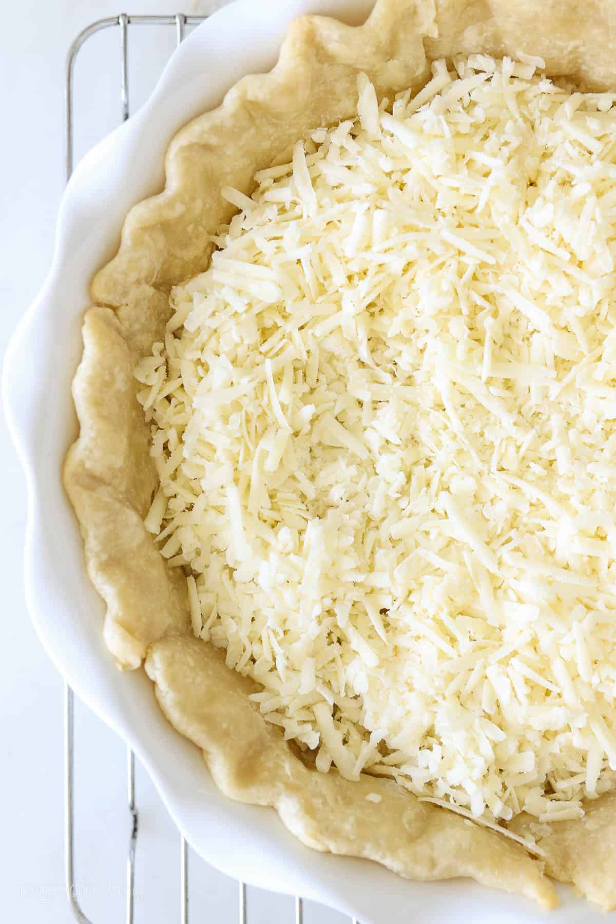 Overhead view of shredded cheese in a pie crust