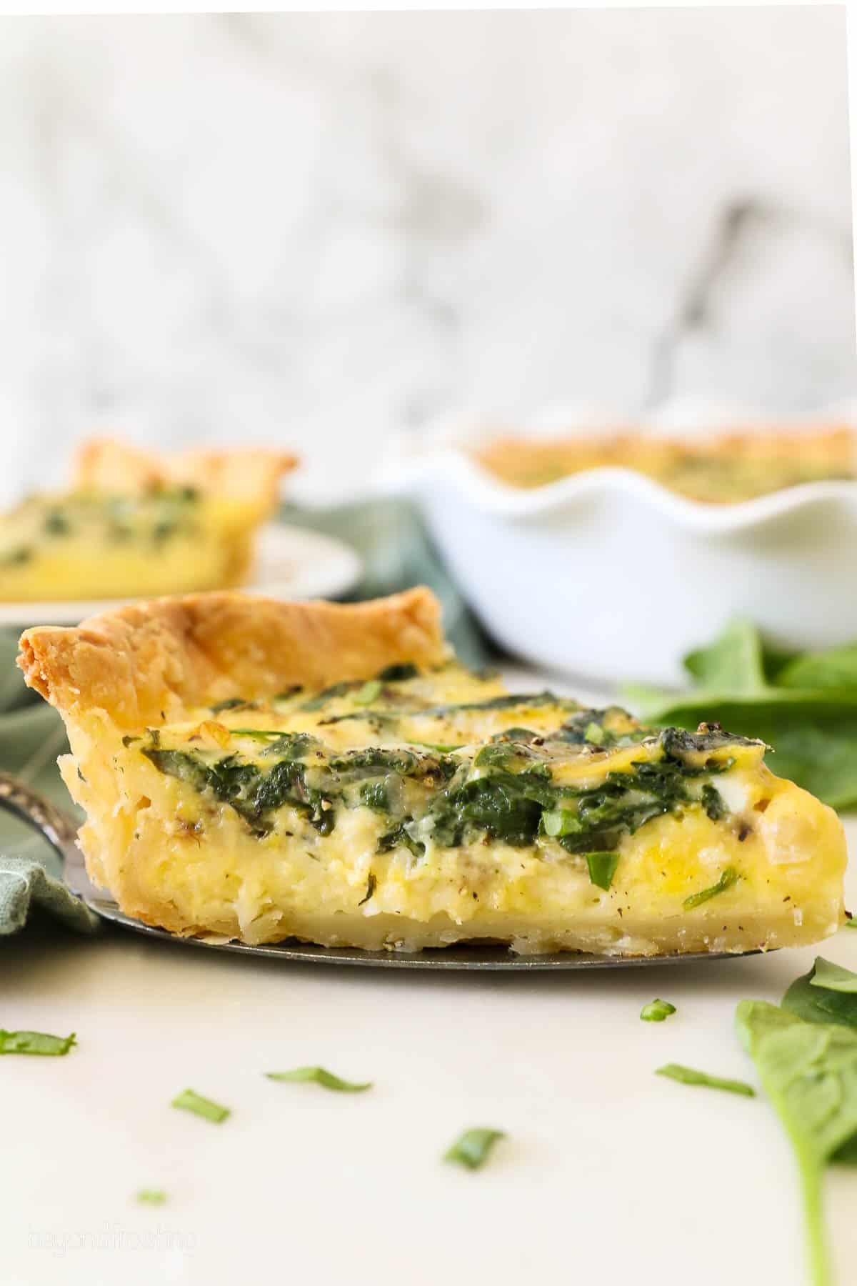 A slice of spinach and cheese quiche