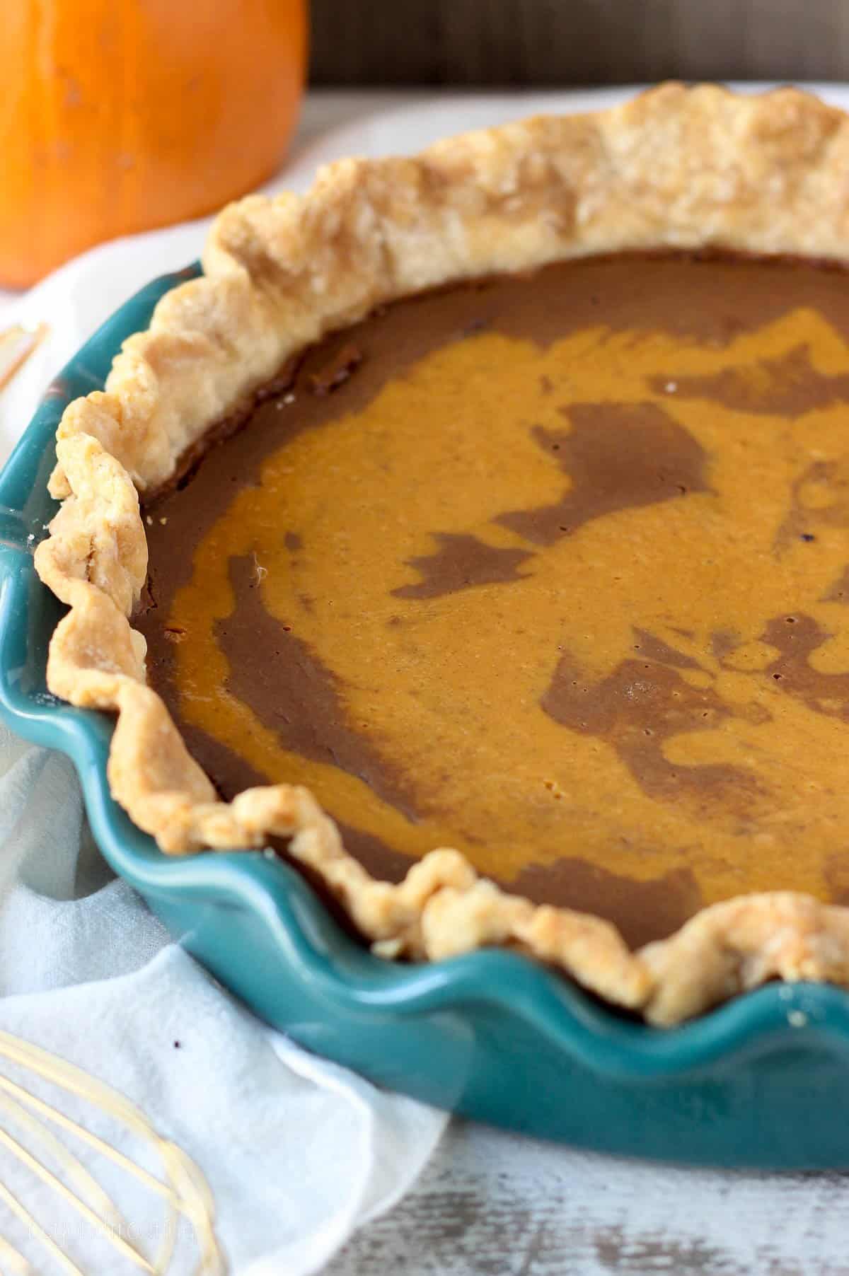 side view closeup of a pumpkin pie in a baking dish