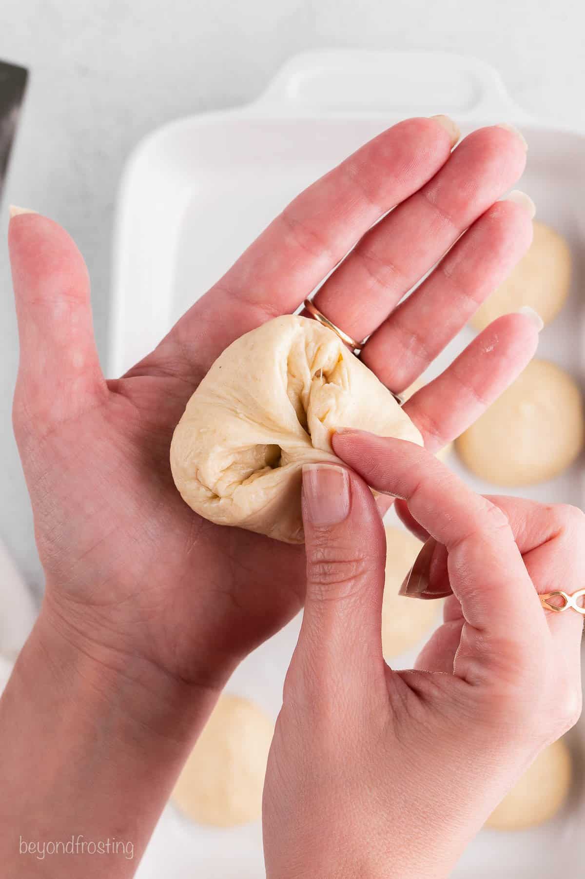 A hand forming a ball of dough