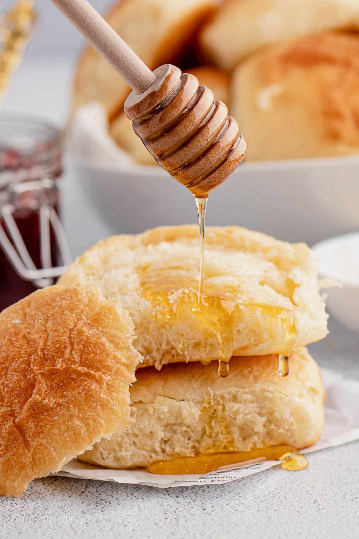 Honey being drizzled over homemade rolls