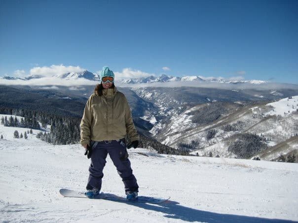 Author on her snowboard at the top of a mountain