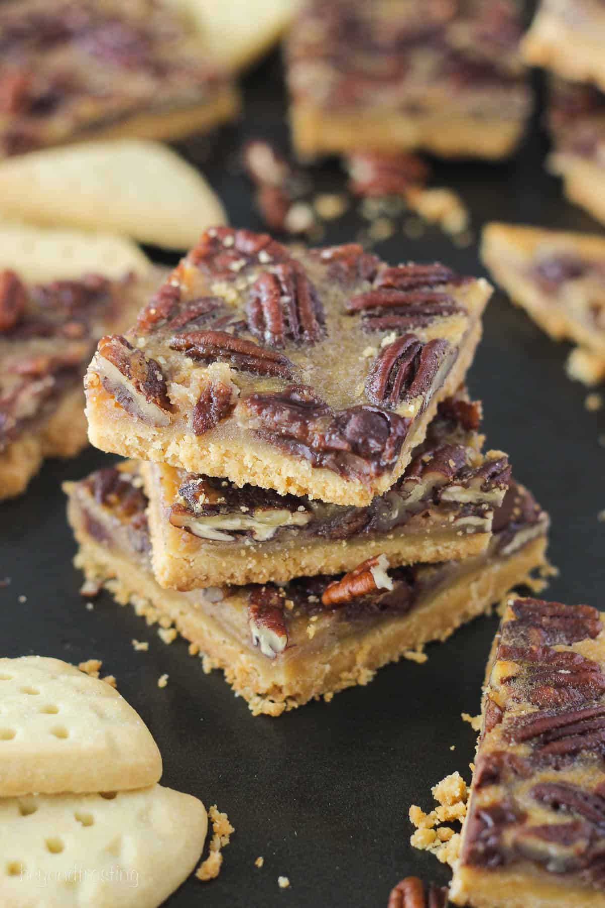 overhead of three pecan pie bars stacked surrounded by more pecan pie bars