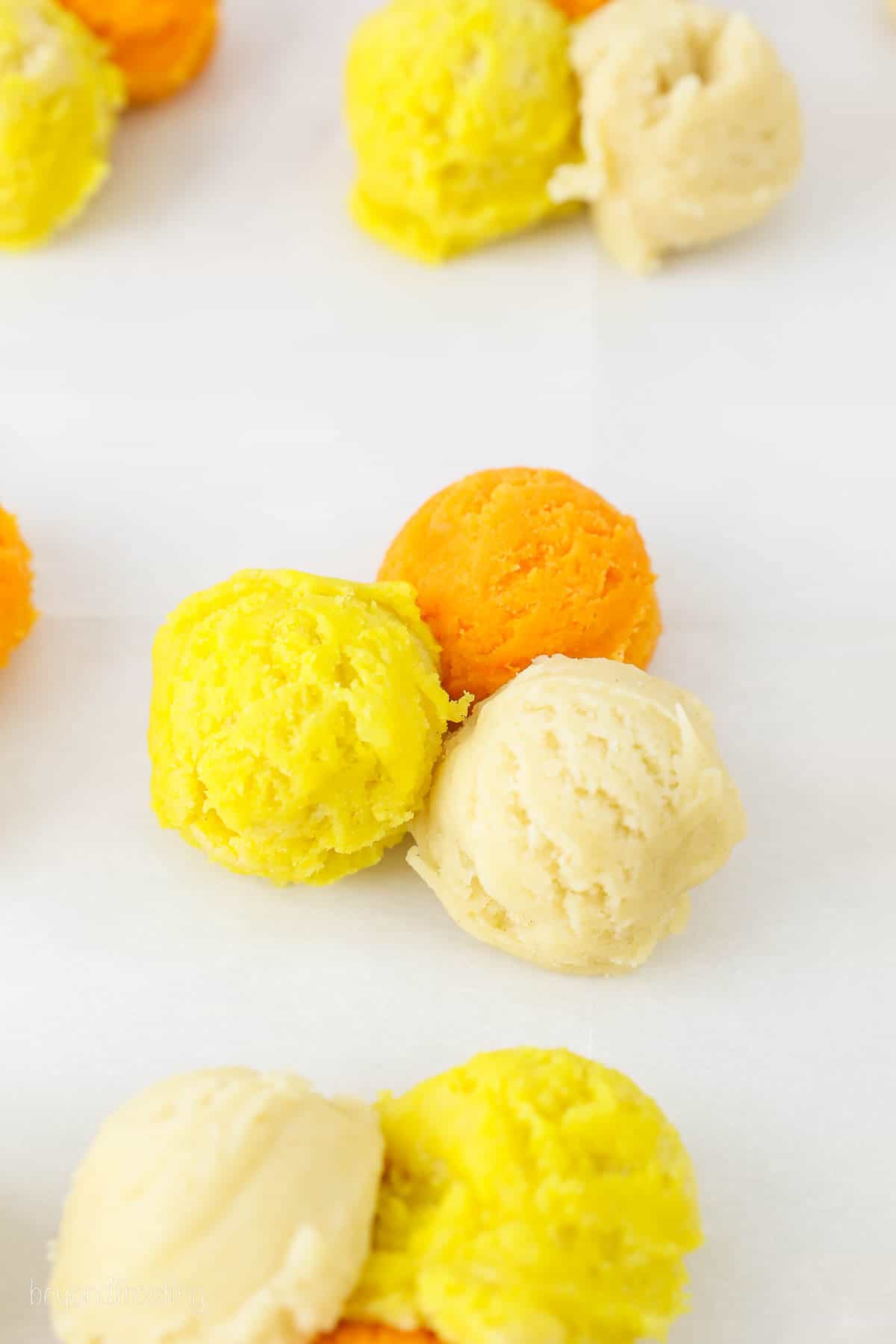 3 scoops of cookie dough color white, yellow and orange.