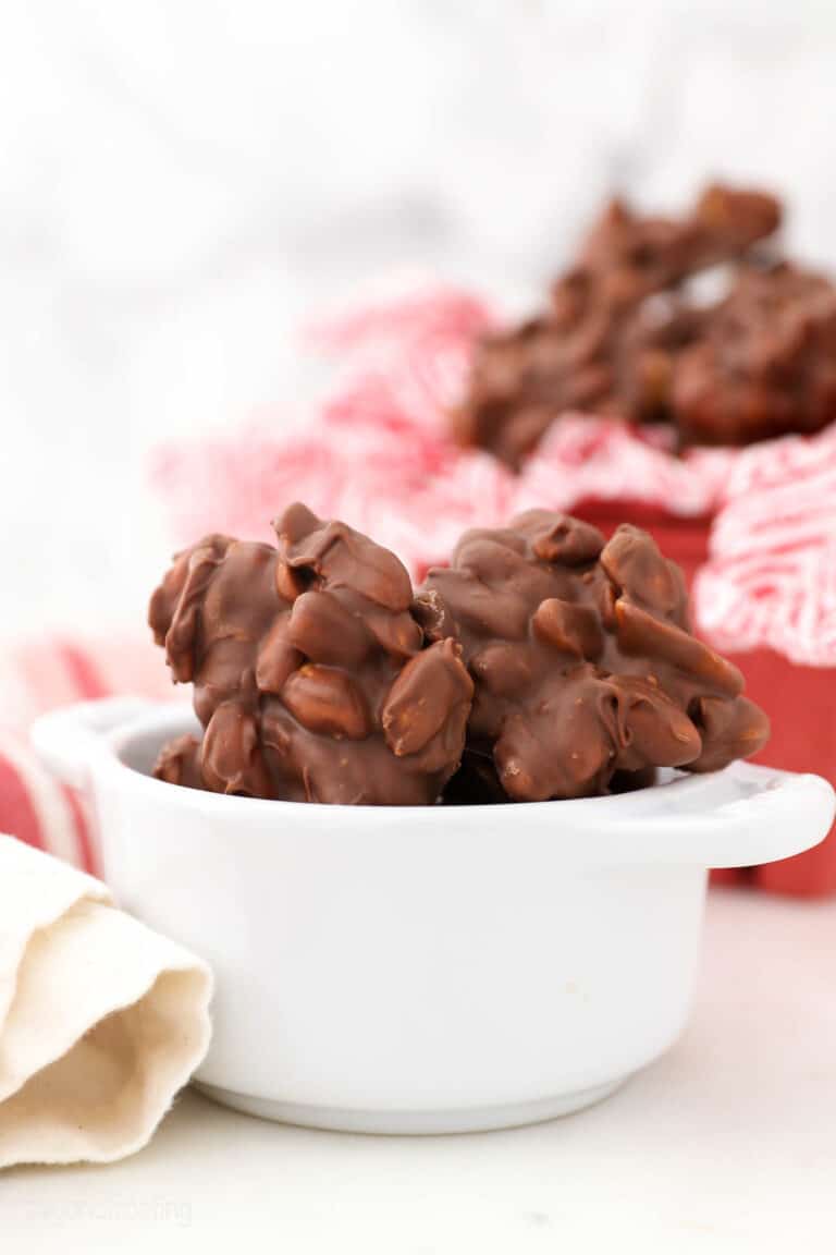 peanut clusters in a small white bowl with more in the background