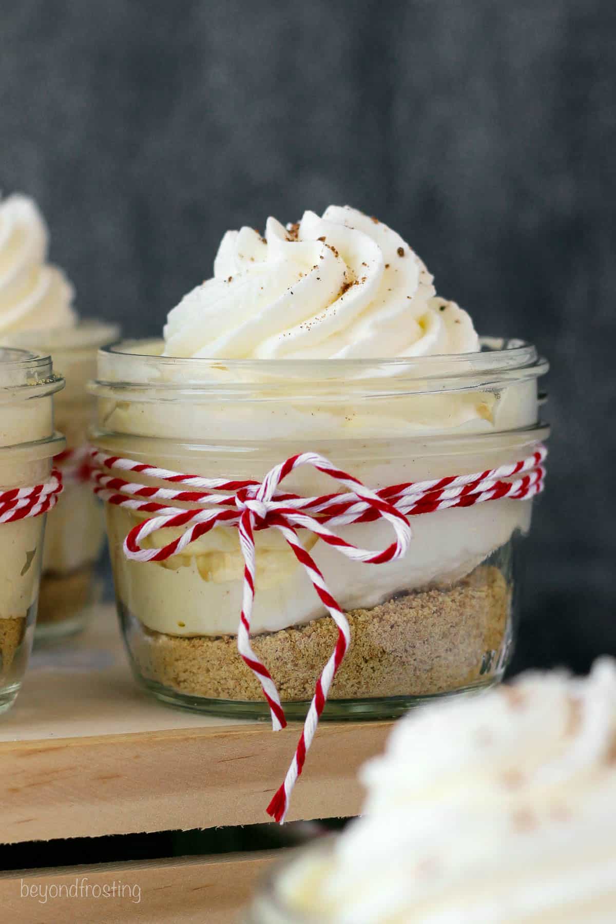 side view of a jar with a pudding parfait tied with a red and white twine