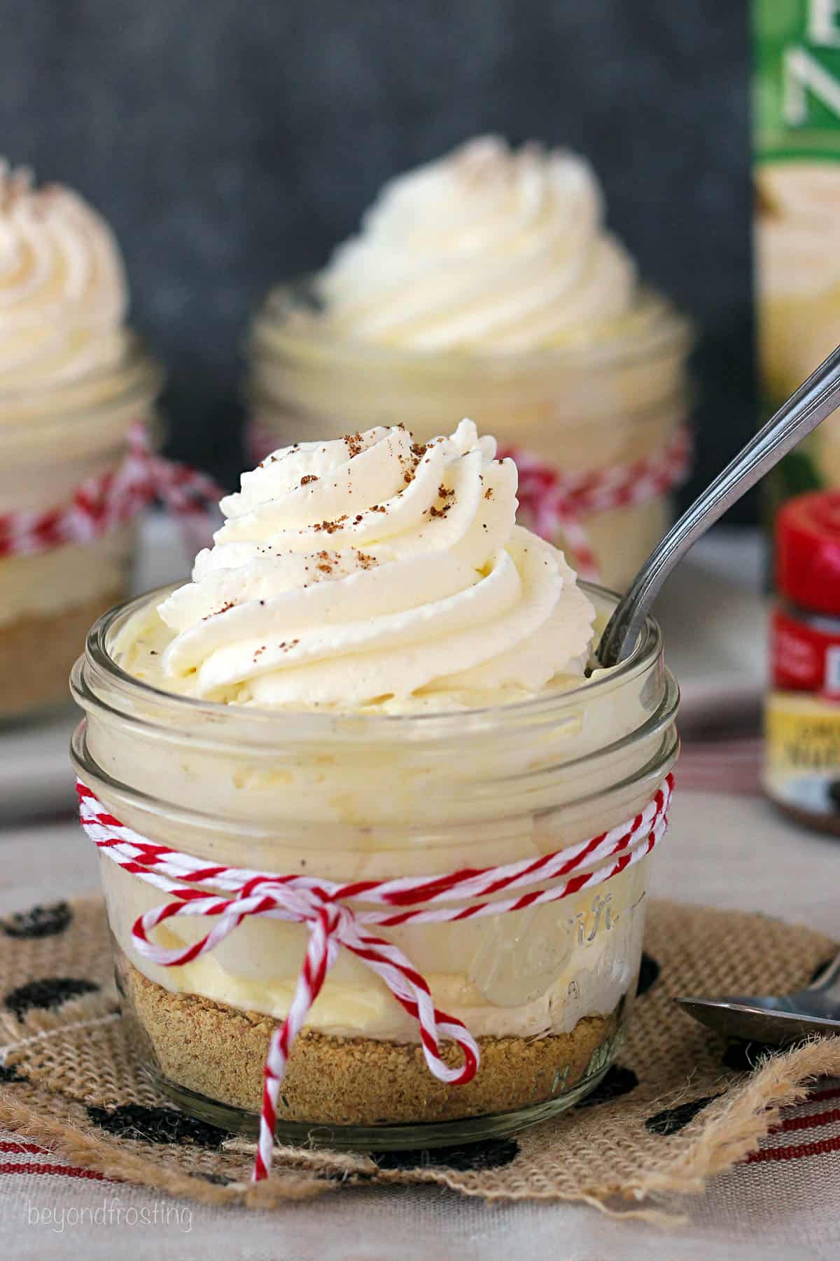 an eggnog pudding parfait with a spoon in it and more in the background