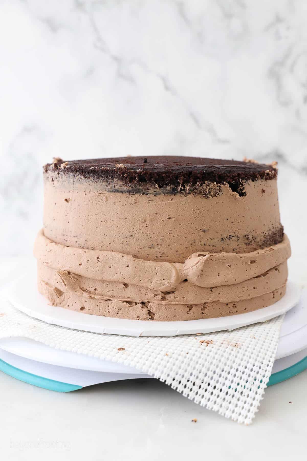 Nutella frosting is piped on outside of chocolate cake.