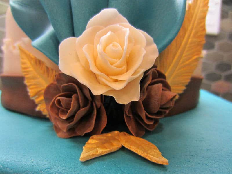close up of fondant flowers on a fondant covered cake