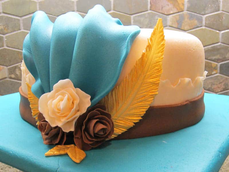 a cake covered in fondant decorated to look like a fancy hat