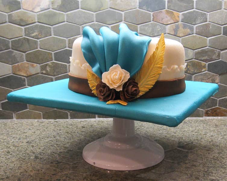 a cake covered in fondant decorated to look like a fancy hat