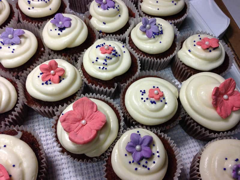 frosted cupcakes with gum paste flowers and sprinkles
