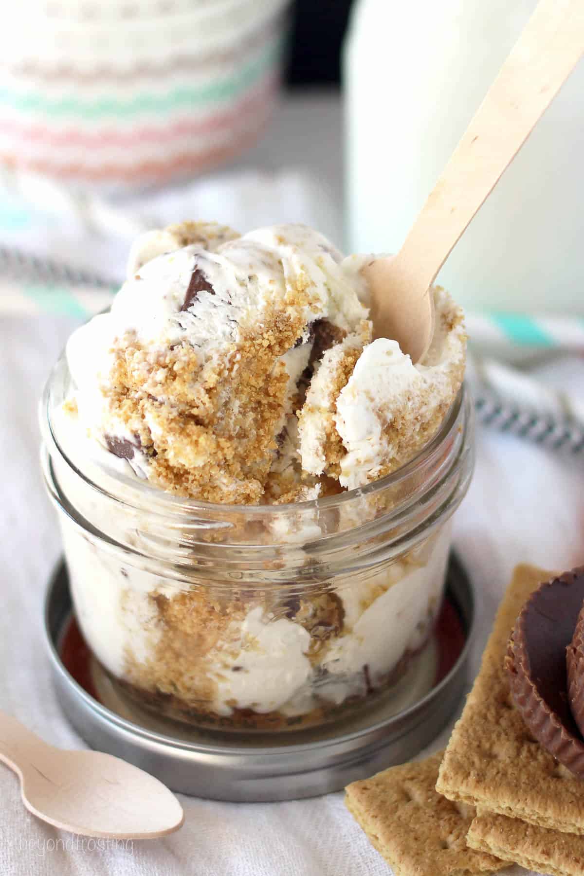 overhead of a jar with peanut butter ice cream and a plastic spoon