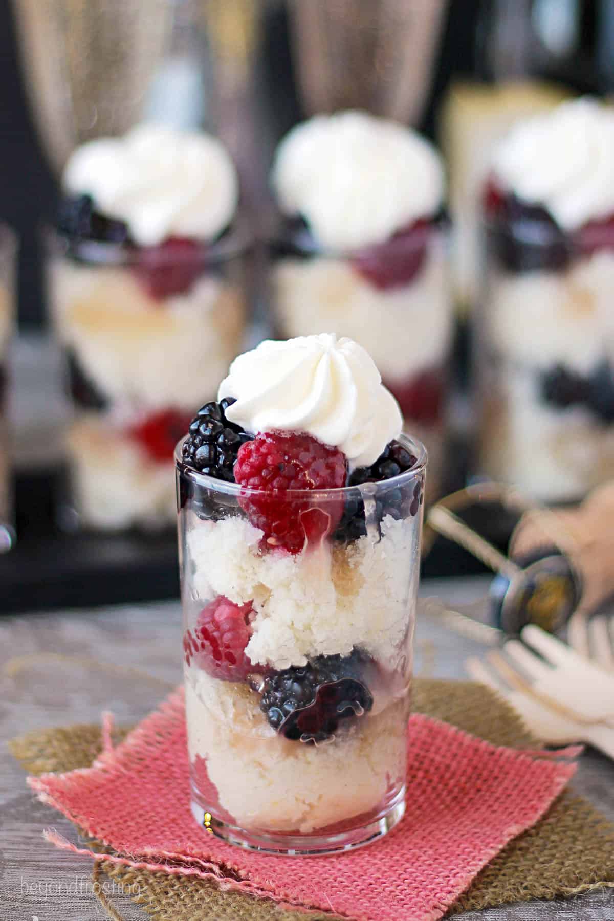 overhead side view of a champagne parfait with berries and whip