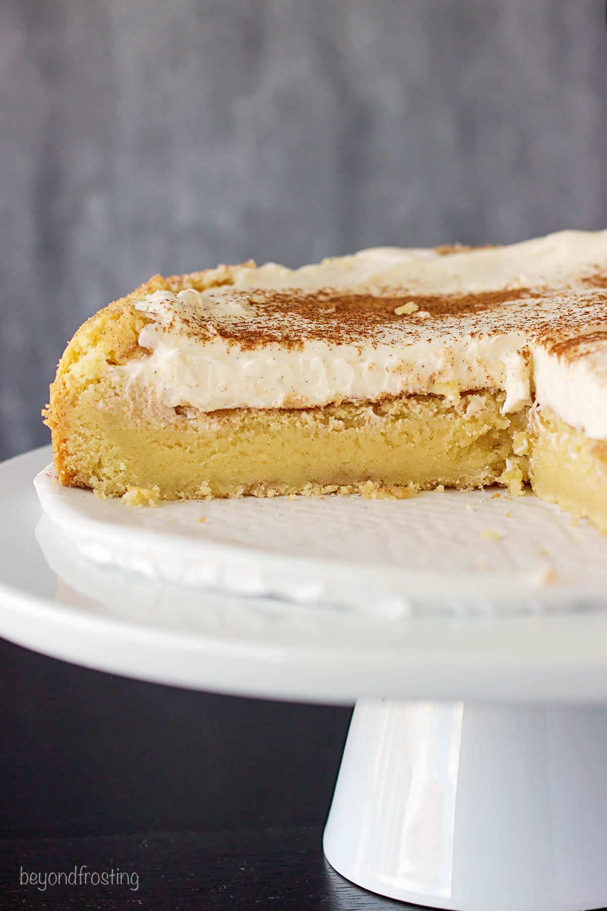 a snickerdoodle cookie pie on a cake stand with some pieces cut out