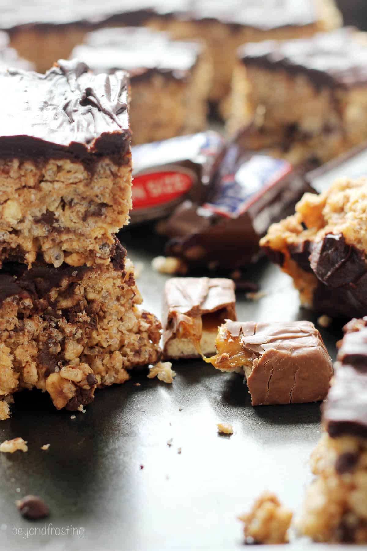 side view of two snickers rice krispie treats stacked with more in the background