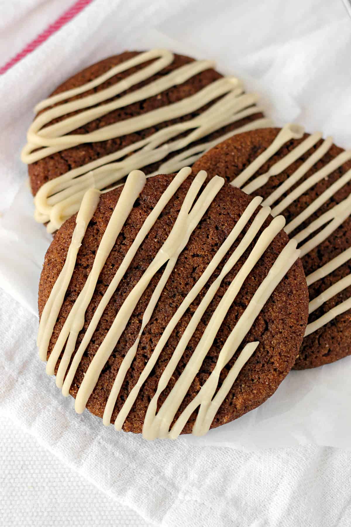 overhead of three molasses cookies drizzled with glaze leaning on one another