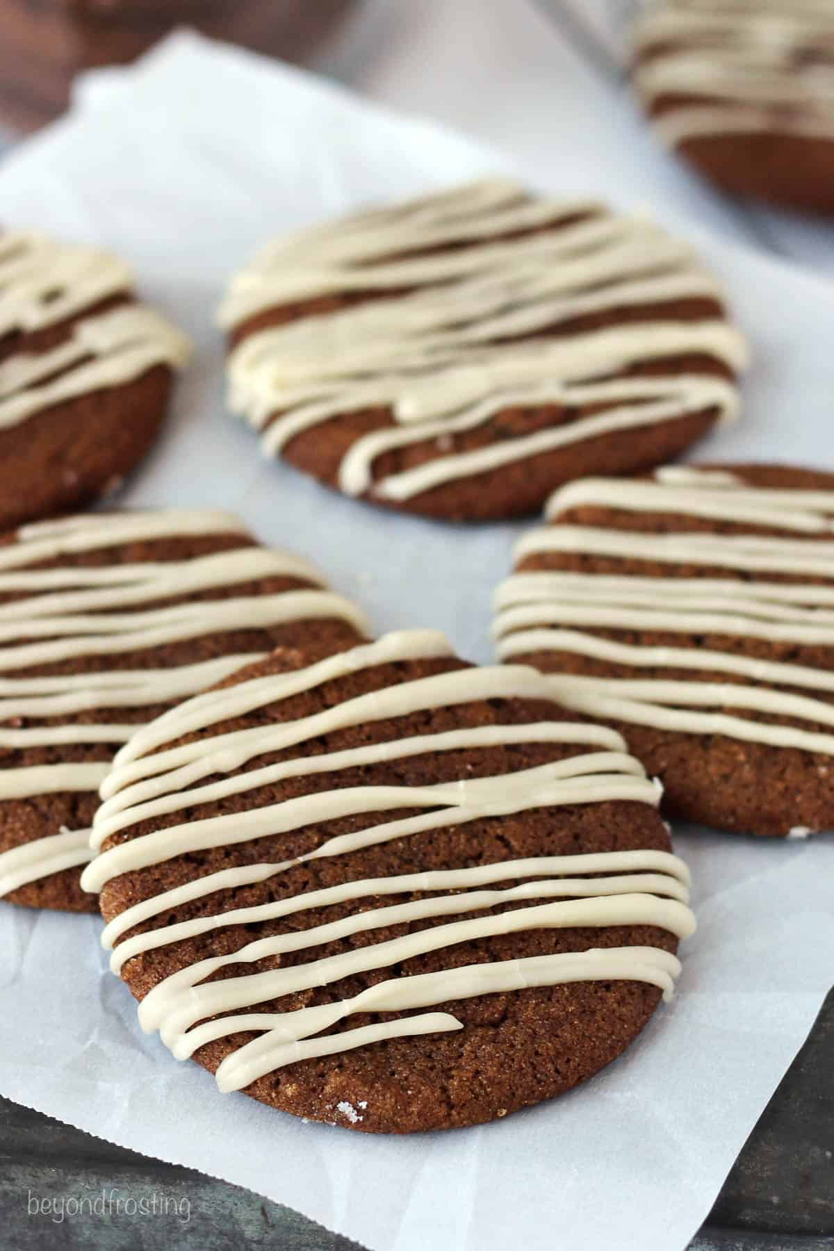 side view of soft baked molasses cookies on a piece of parchment paper