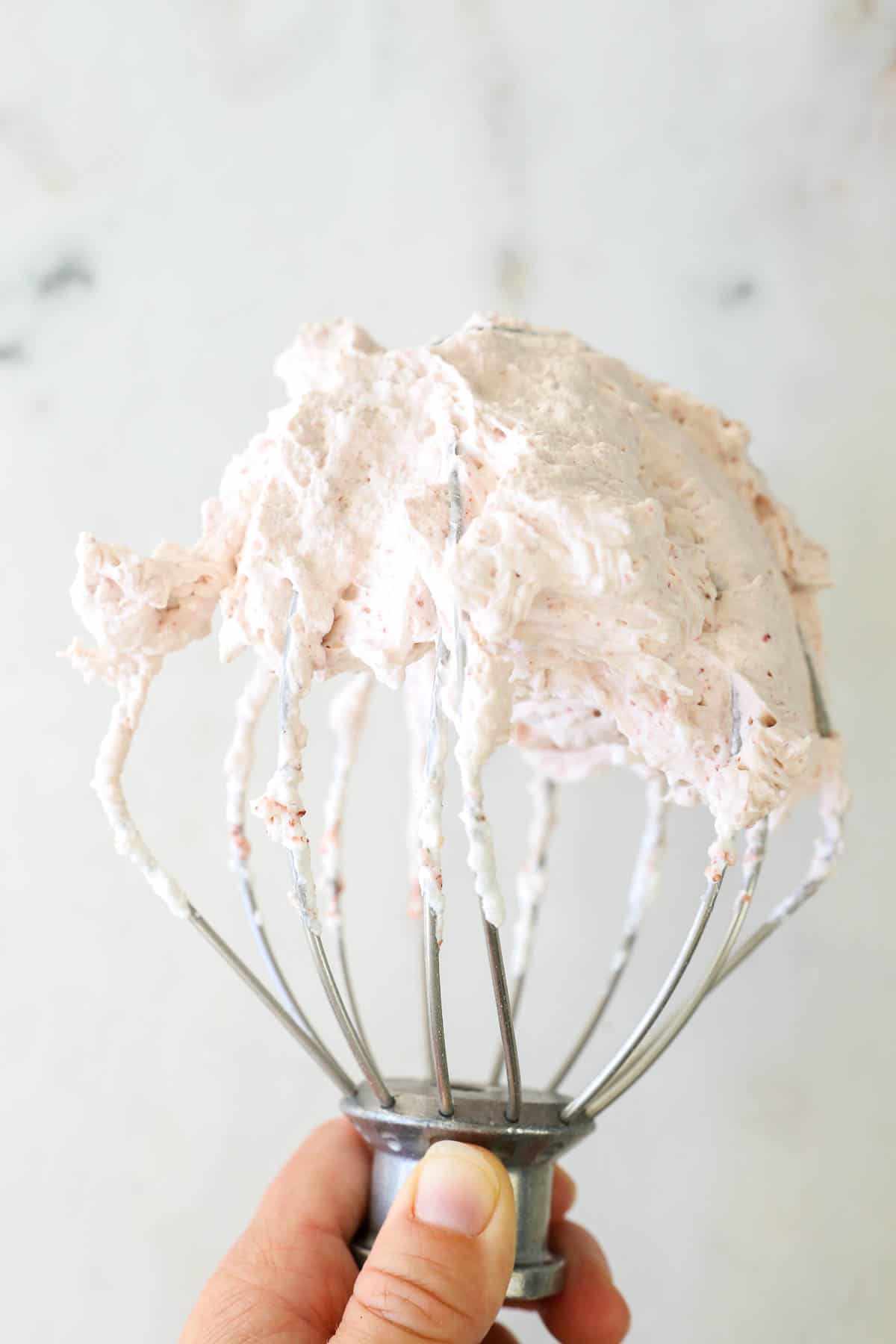 A KitchenAid Whisk attachment with strawberry whipped cream