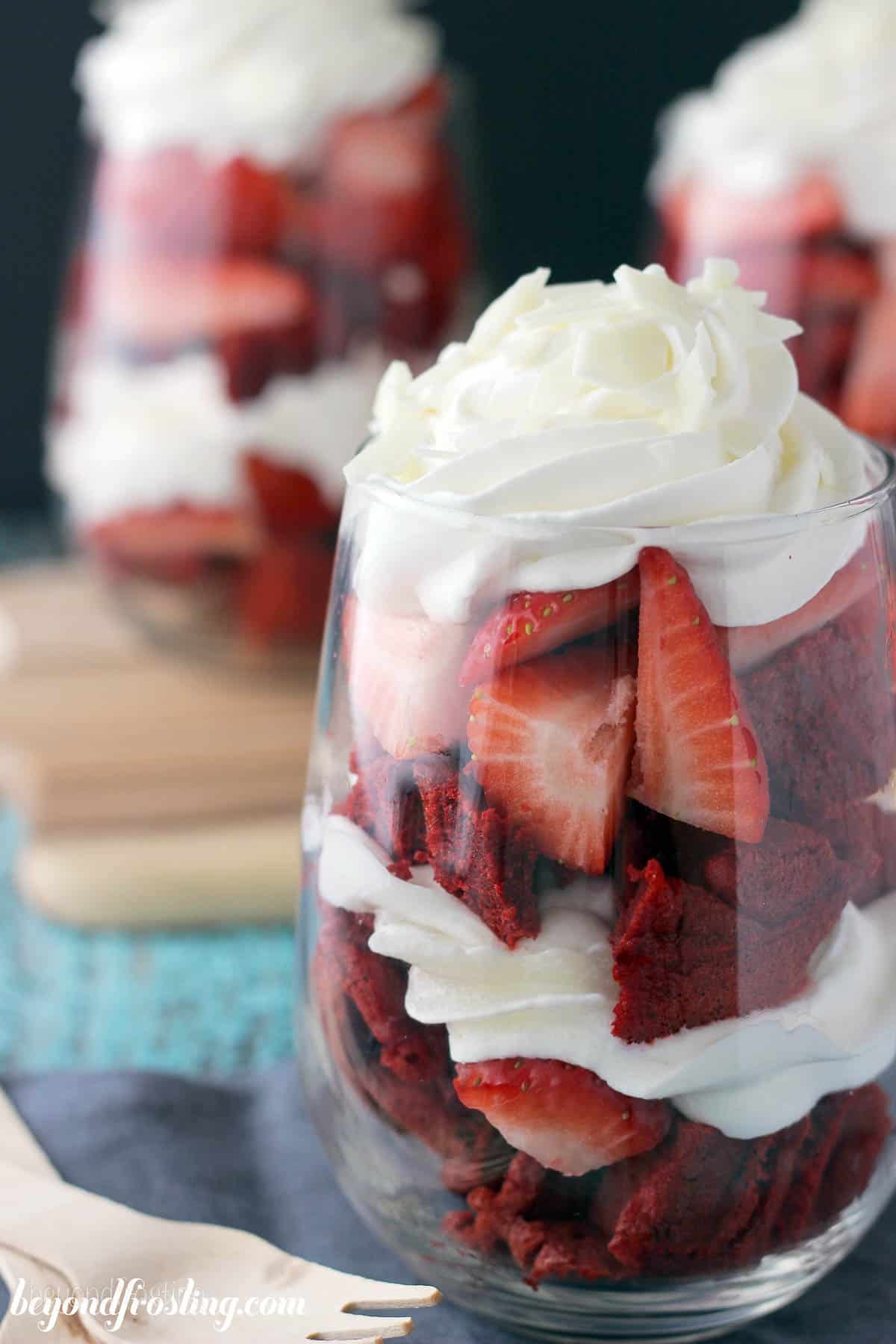 side view of a waffle parfait topped with whip with more parfaits in the background
