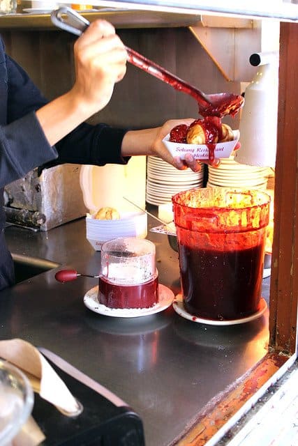 Berry sauce being poured over aebleskivers