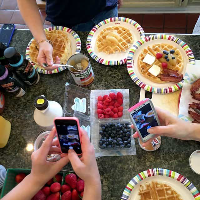 Overhead view of plates of homemade waffles with berries