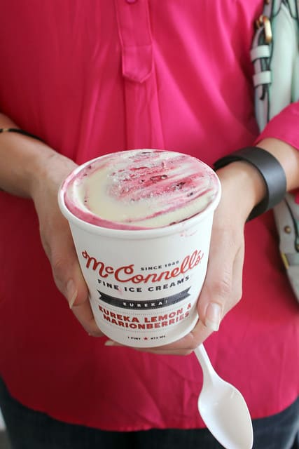 Hands holding a pint of McConnell's ice cream lemon strawberry ice cream