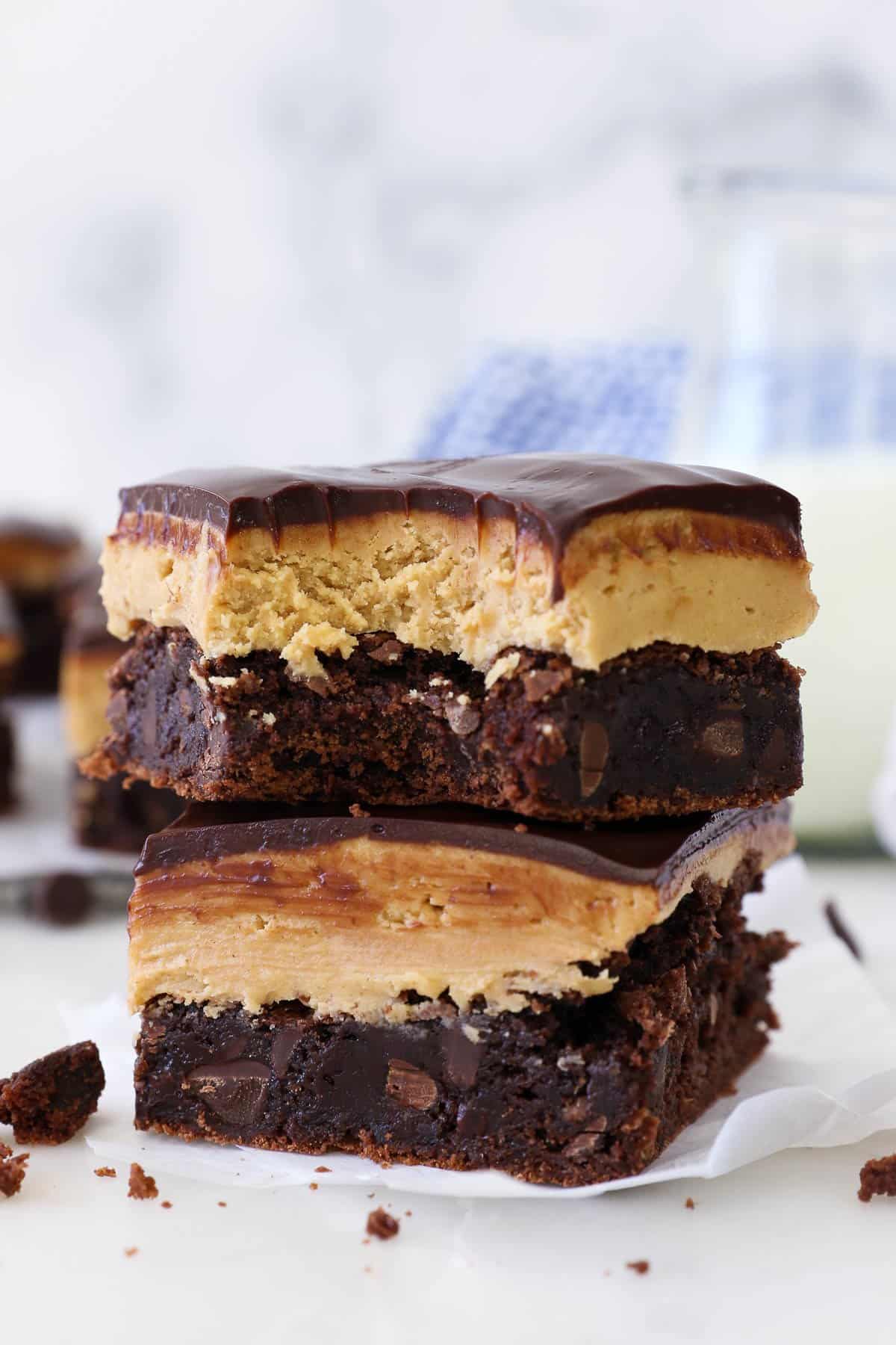 Two buckeye brownies stacked on top of one another, with a bite missing from the top brownie..