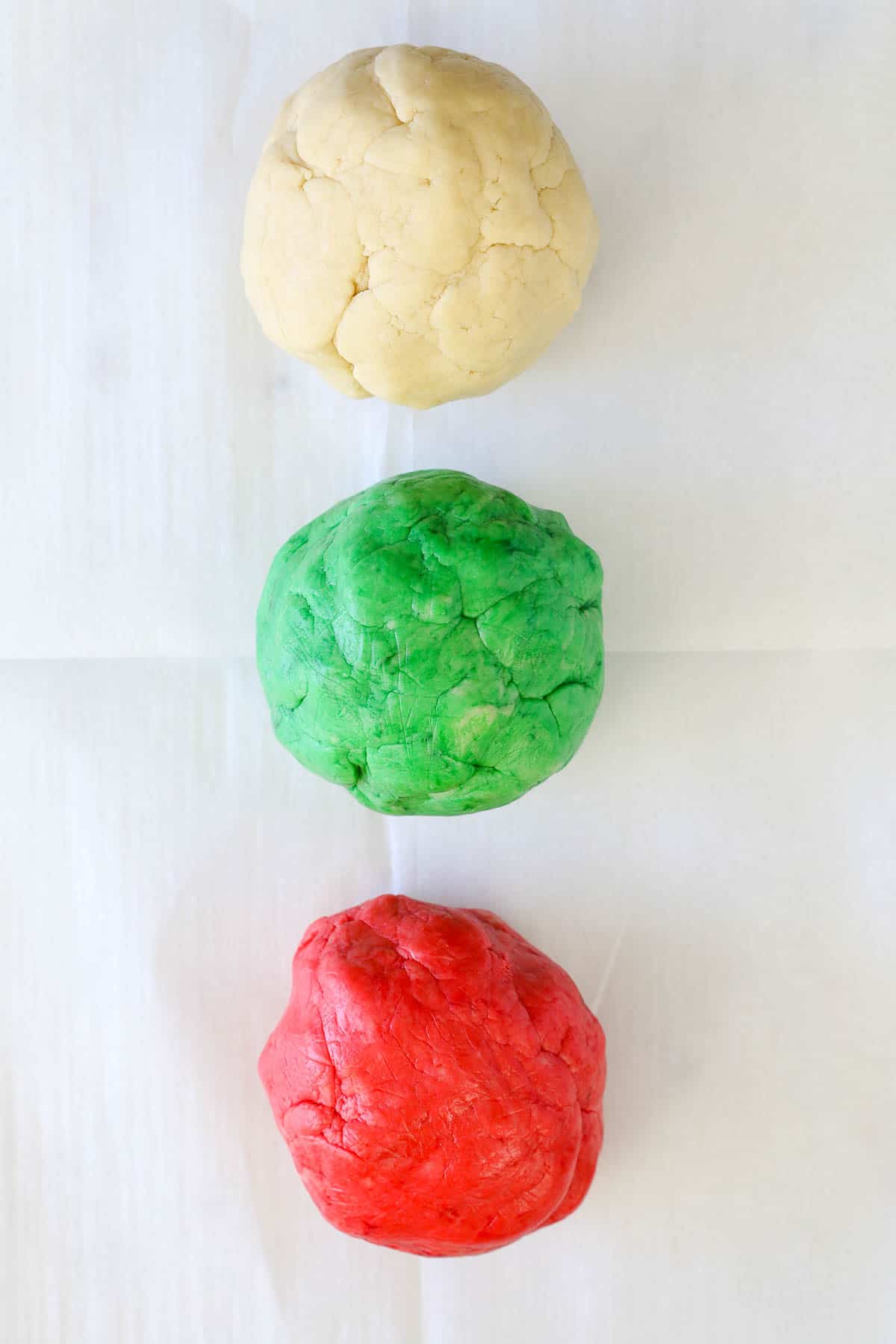 Three cookie dough balls: a white, a green, and a red ball in a row.