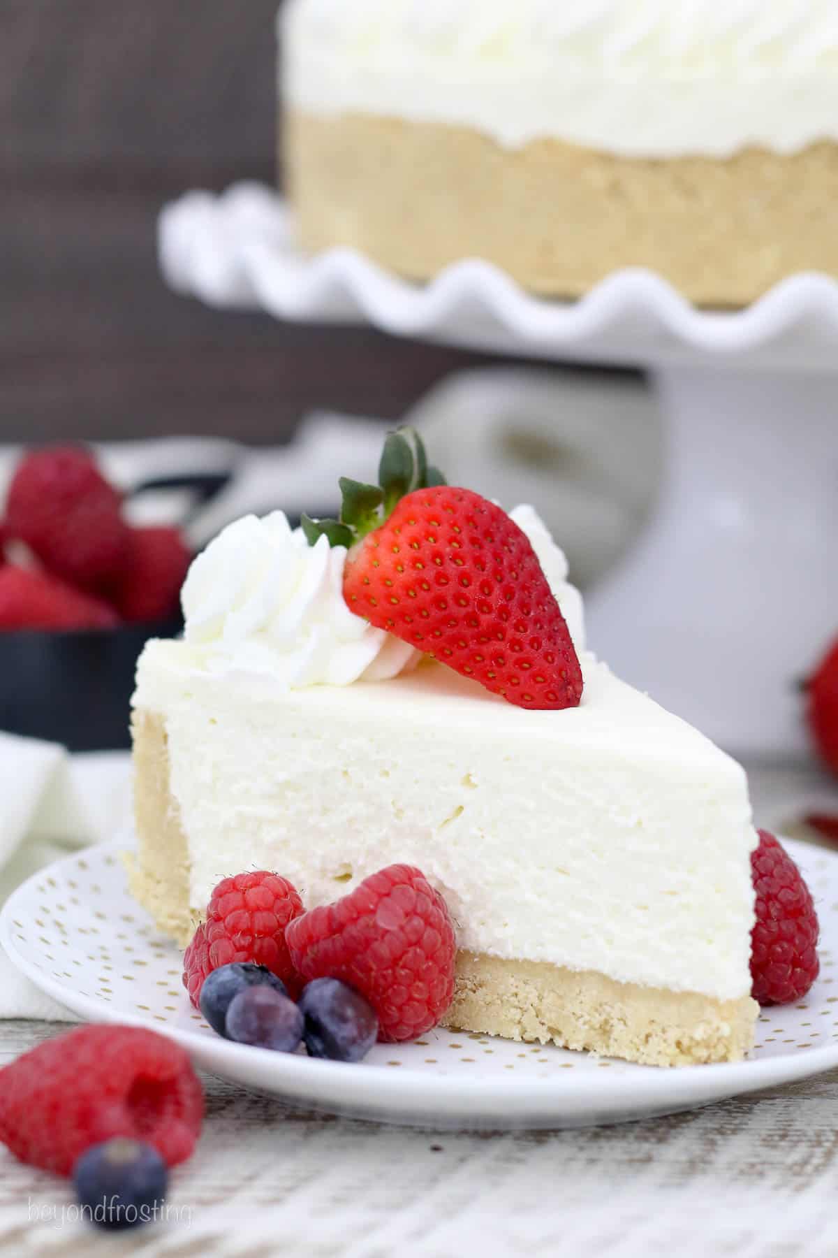 side view of a slice of cheesecake topped with berries