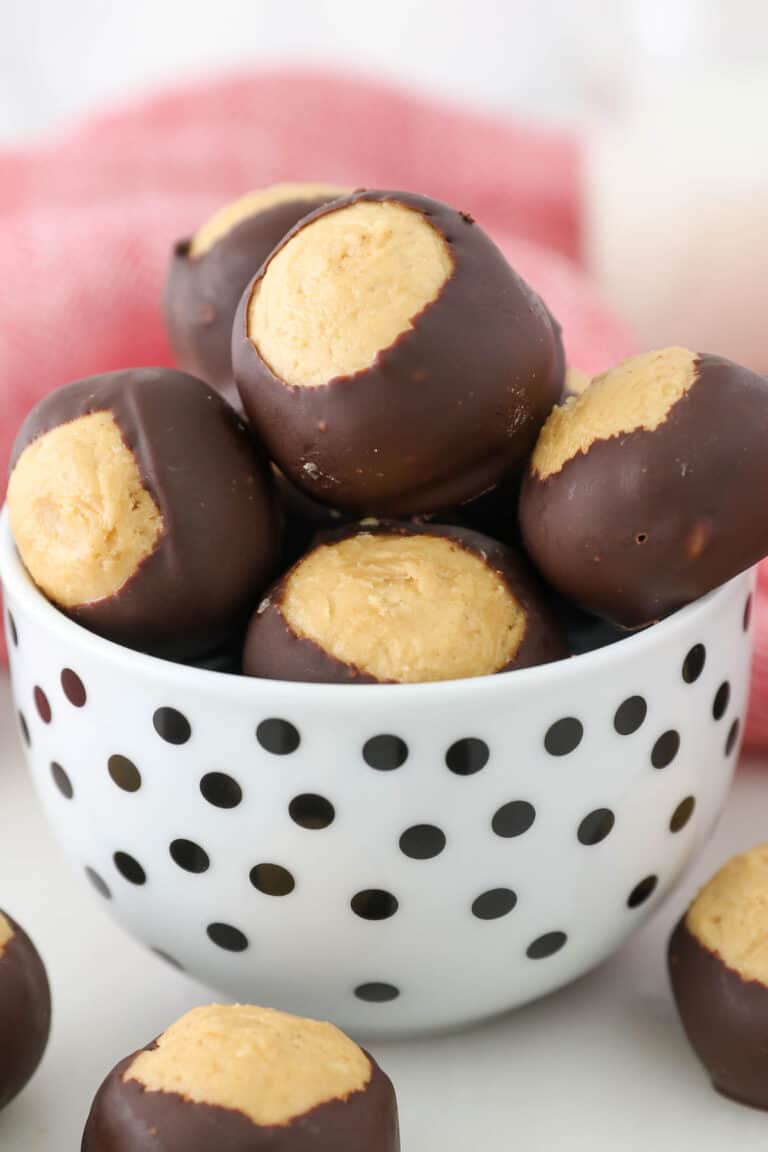 Peanut butter buckeyes in a small white bowl with black polkadots.