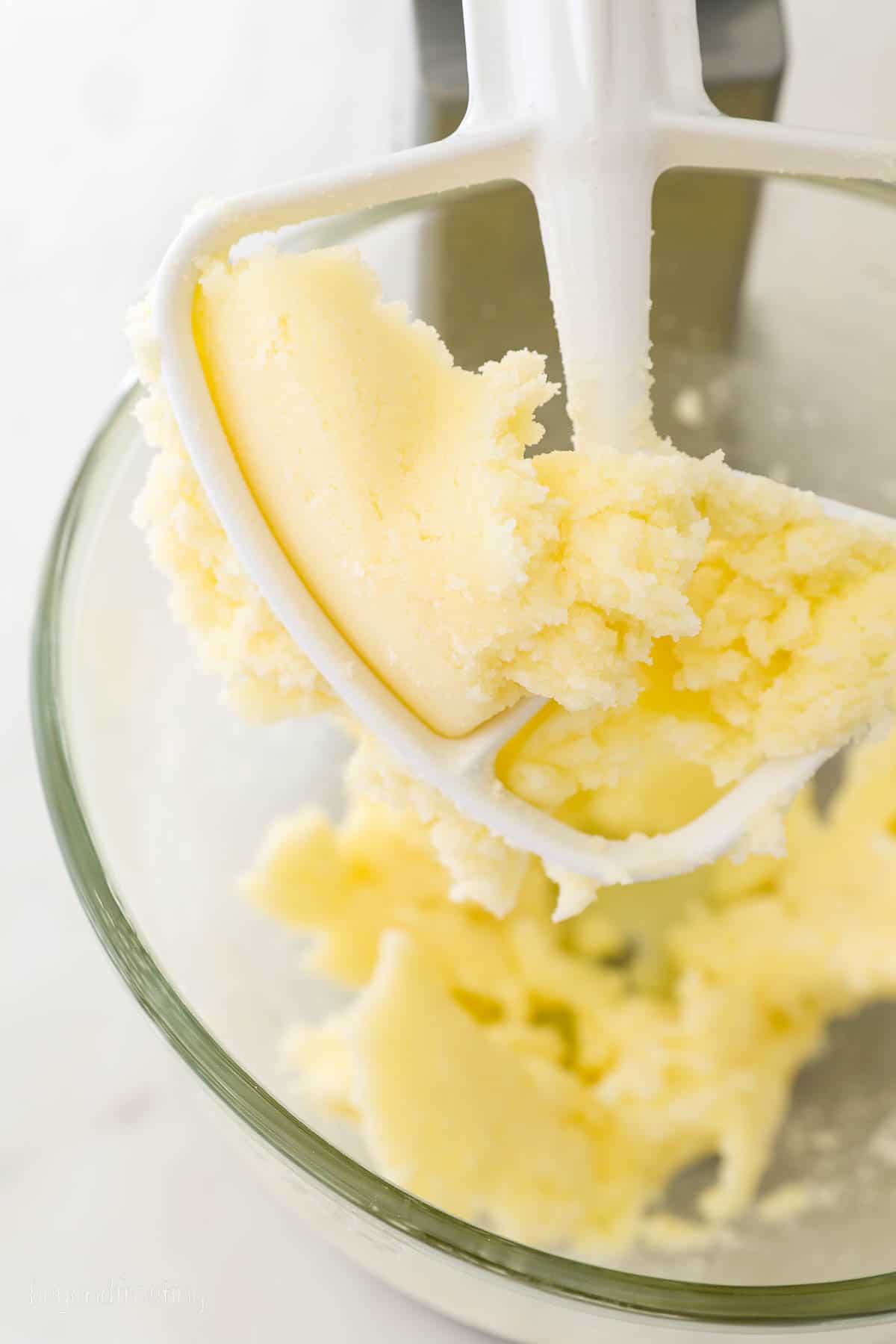 A stand mixer with a beater blade of creamed butter and sugar