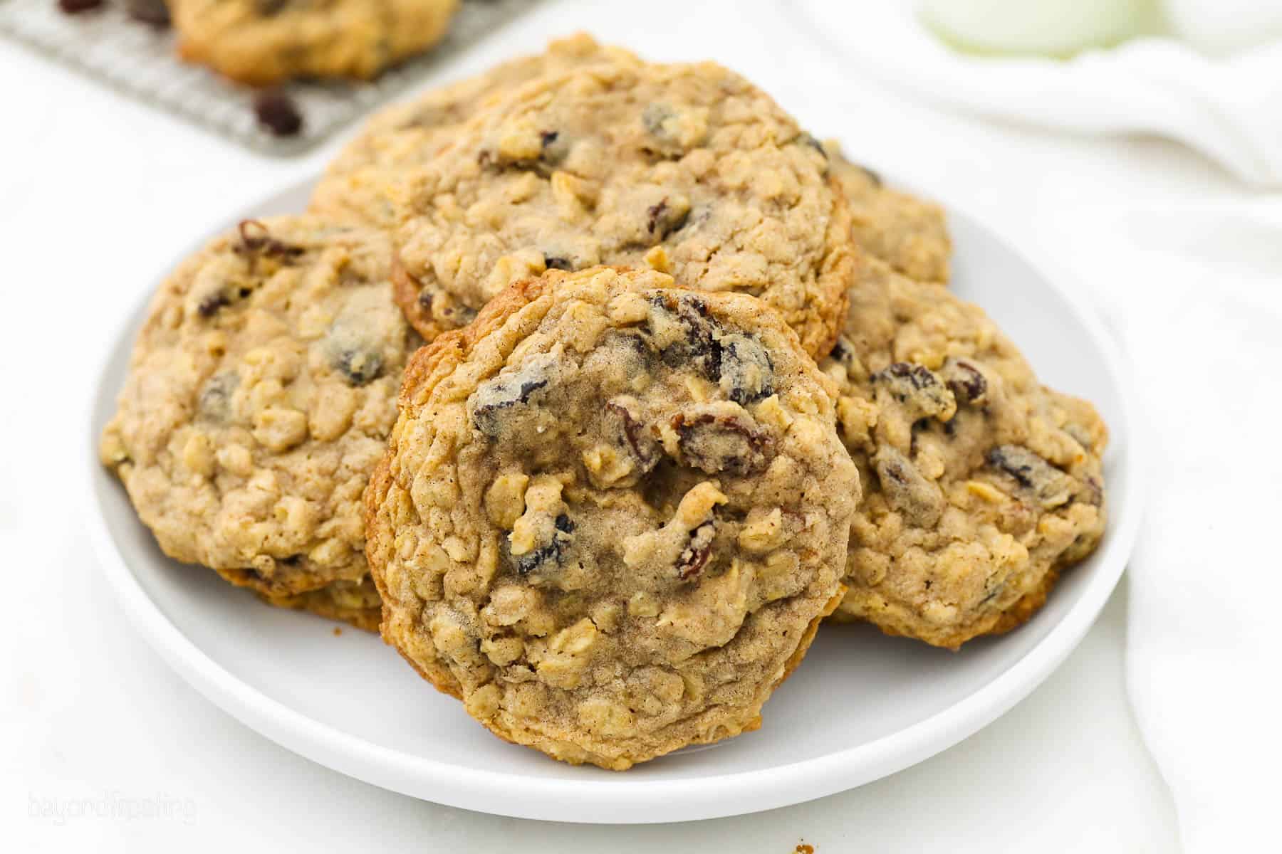 A white plate of oatmeal raison cookies stacked