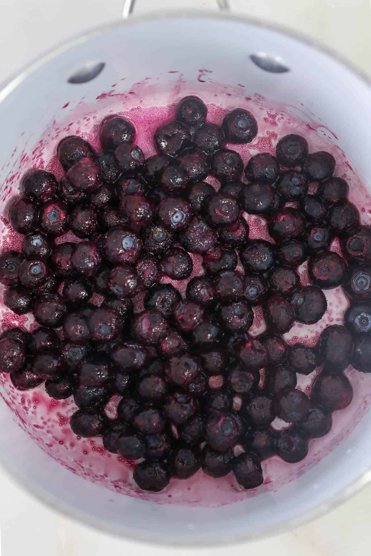 a saucepan with frozen blueberries
