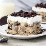 closeup of a square of Oreo cake on a white plate.