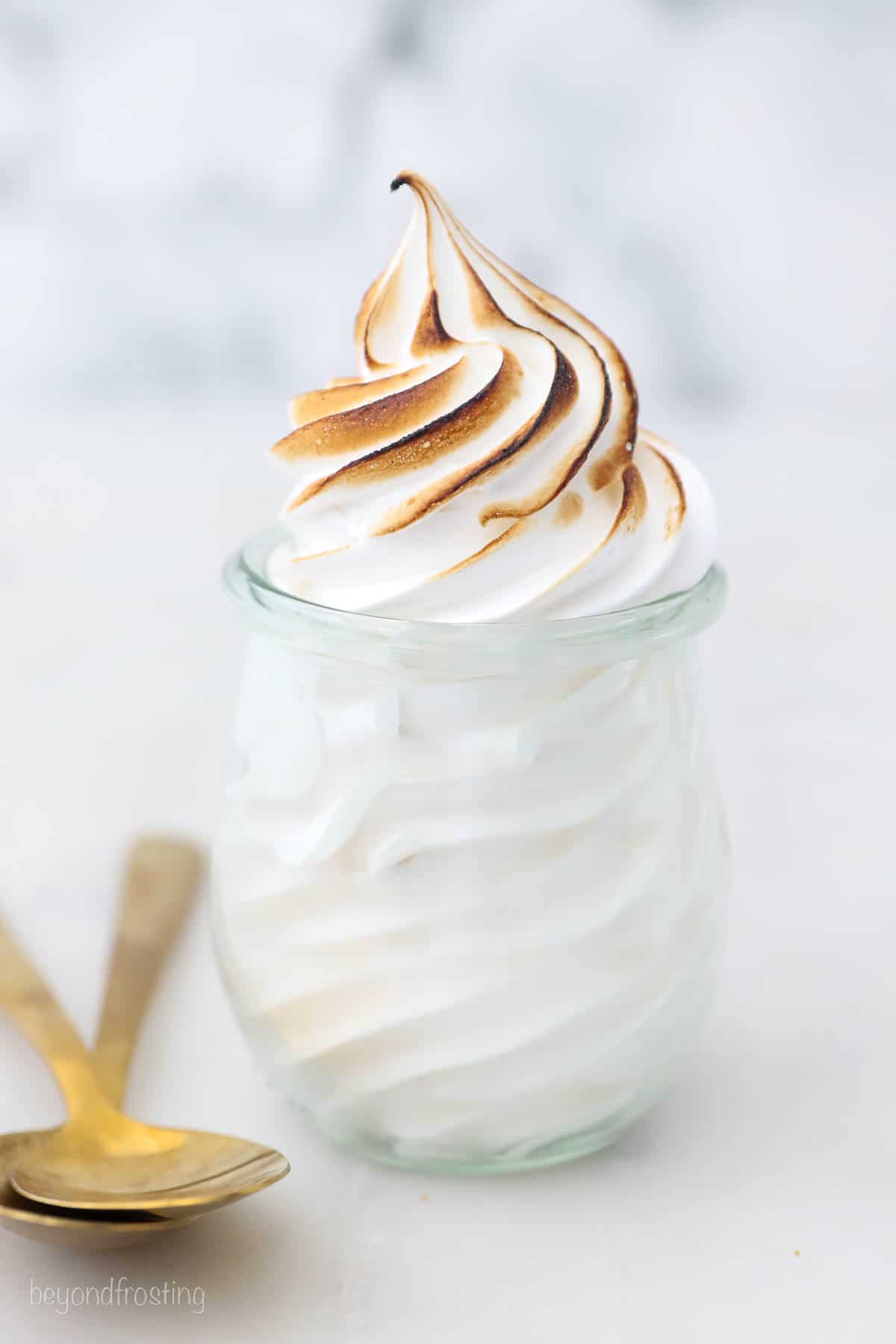 Toasted marshmallow frosting piped into a glass jar.