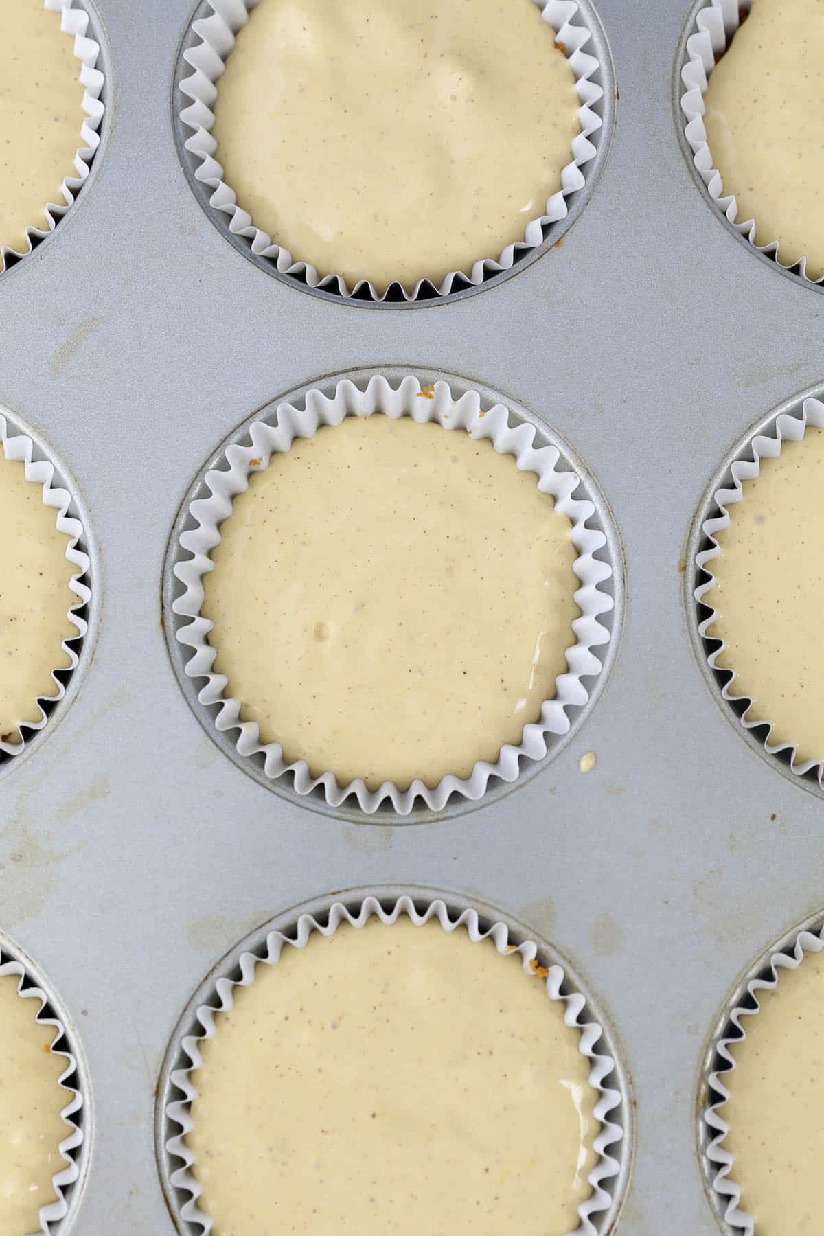 overhead view of a cupcake pan with batter for cheesecake