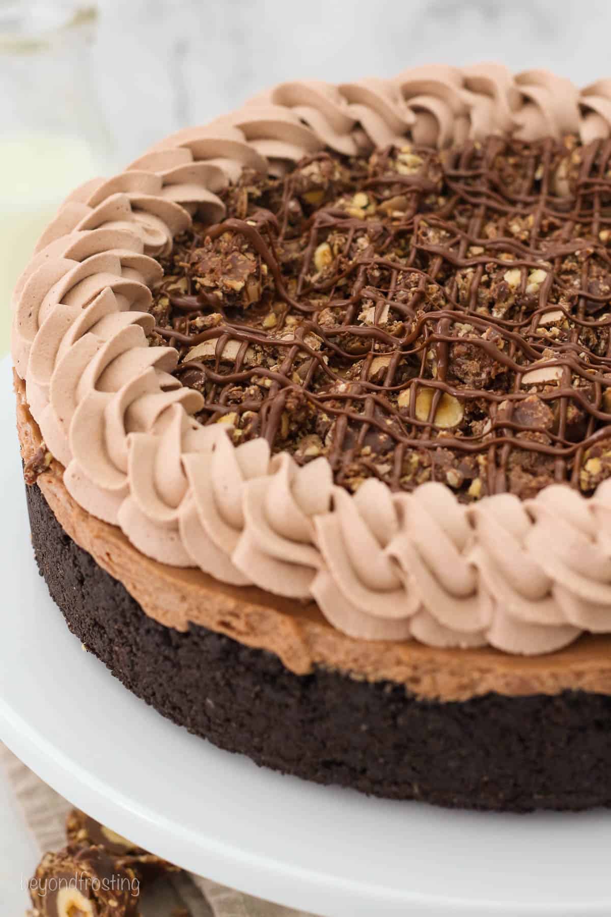 overhead closeup of a whole nutella cheesecake on a cake stand.