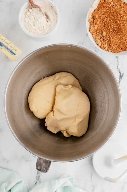 Cinnamon roll dough in a metal mixing bowl.