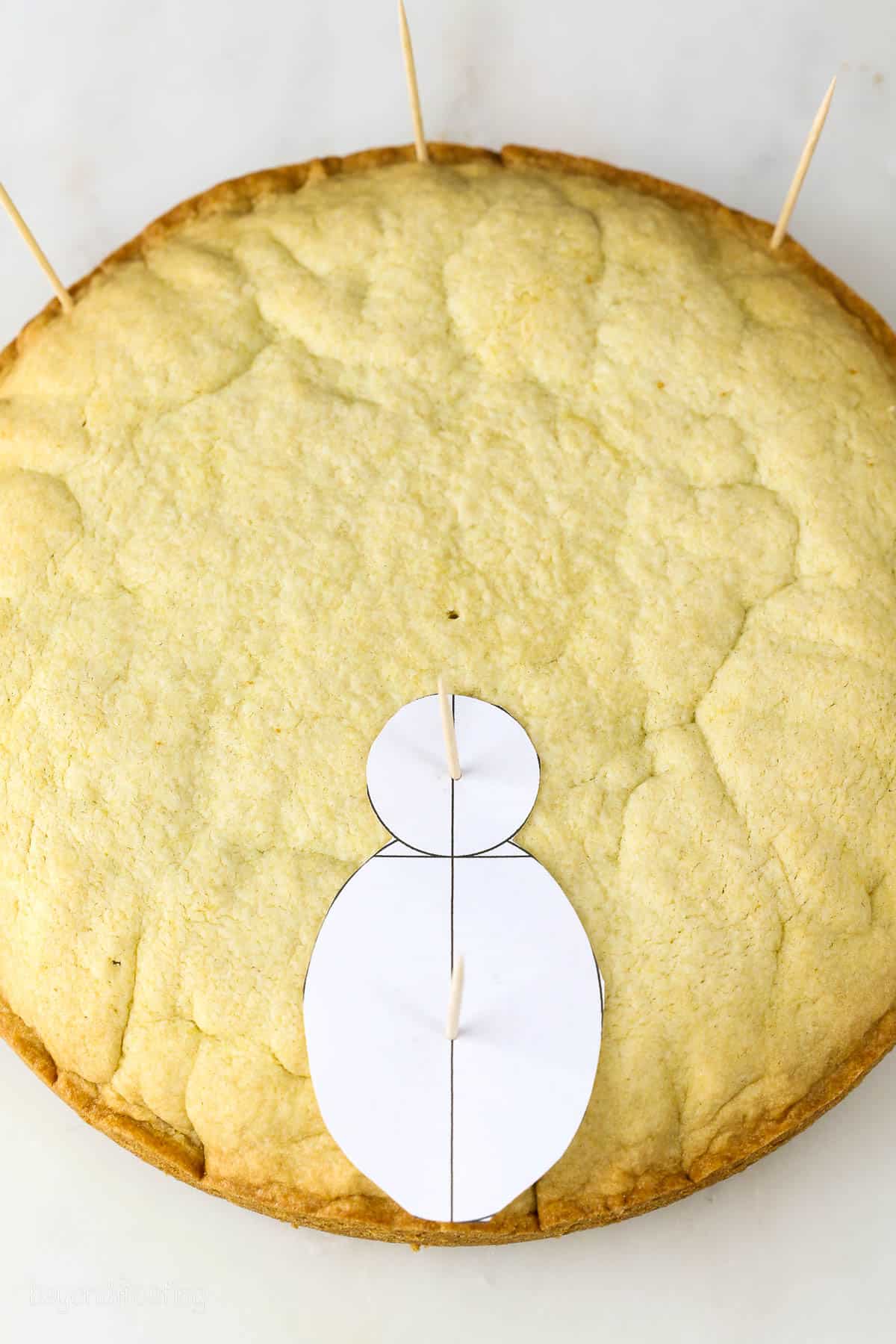 Cookie cake with paper template and toothpicks