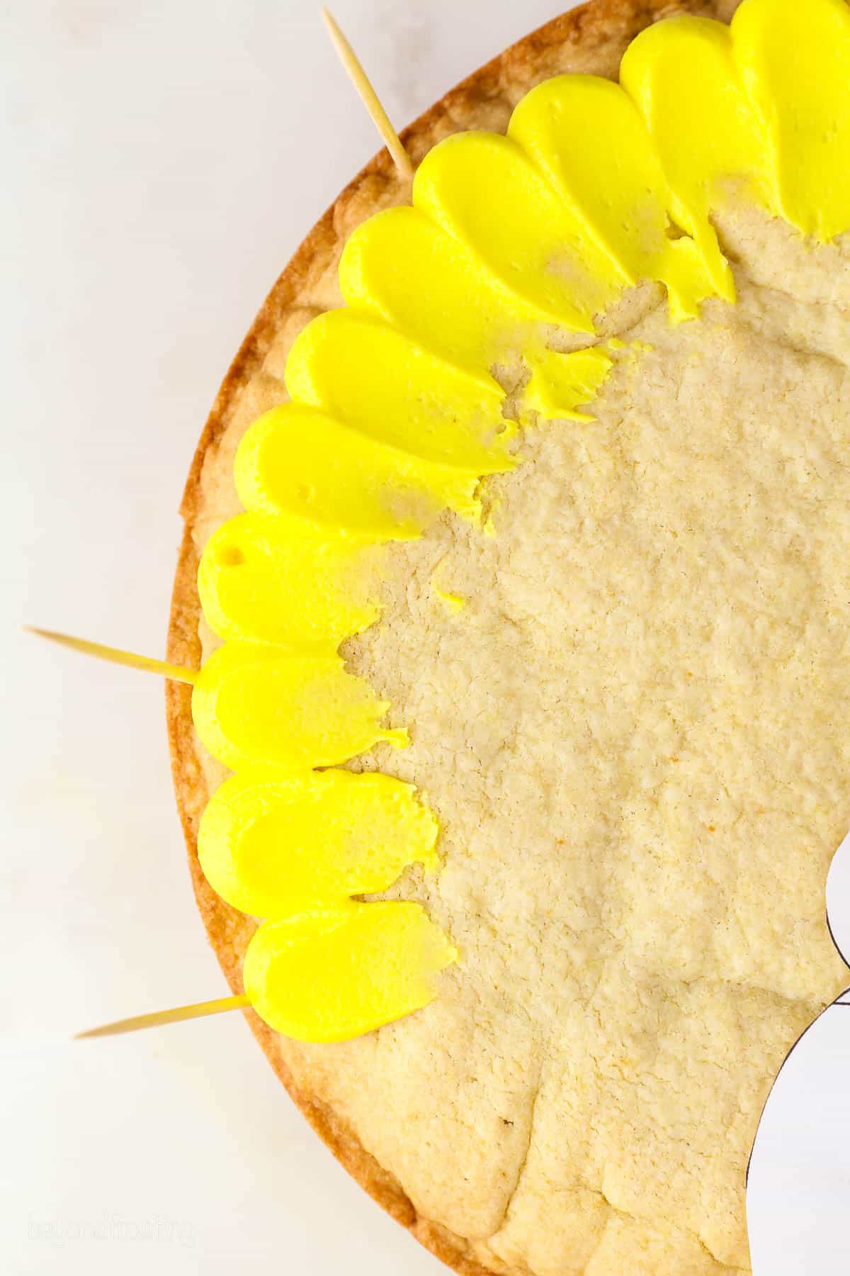 Close up of yellow buttercream pedal frosting technique on a cookie cake