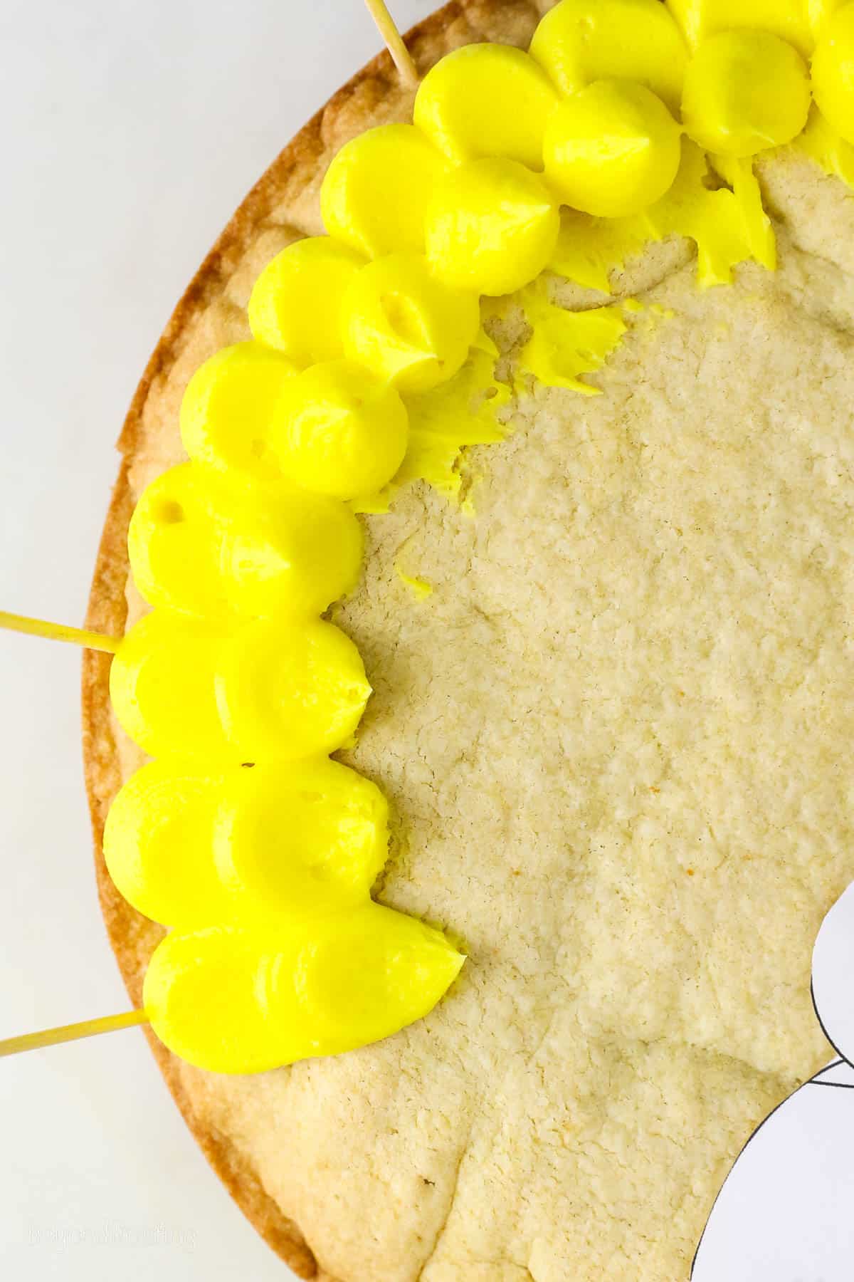 Close up of yellow buttercream pedal frosting technique on a cookie cake