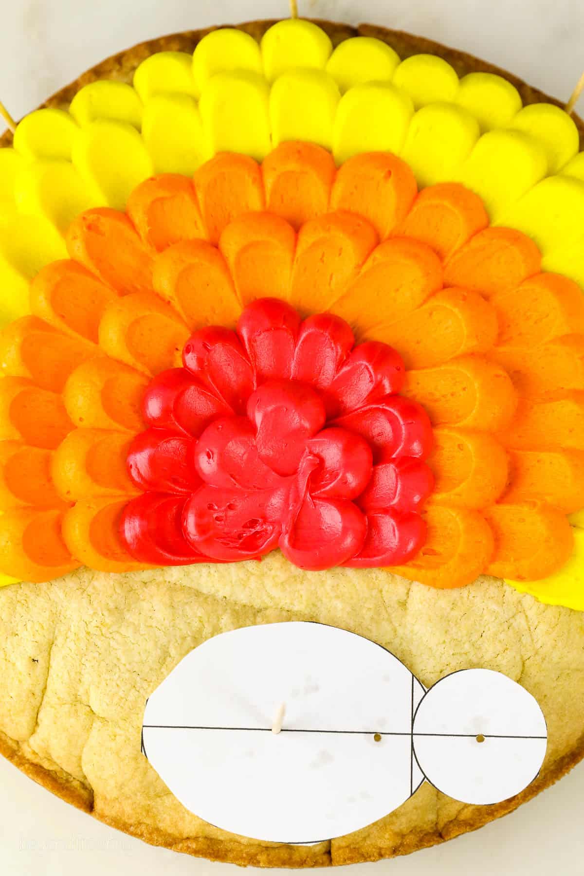 close up of yellow, orange and red buttercream piped to look like turkey feathers